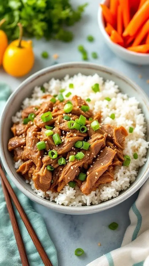 Bowl of Slow Cooker Asian-Inspired Pulled Pork served with rice and garnished with green onions.